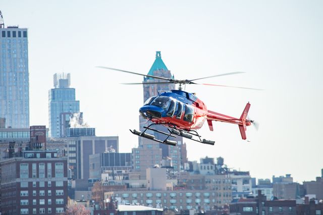 A red-blue helicopter landing on a helipad in New York City.